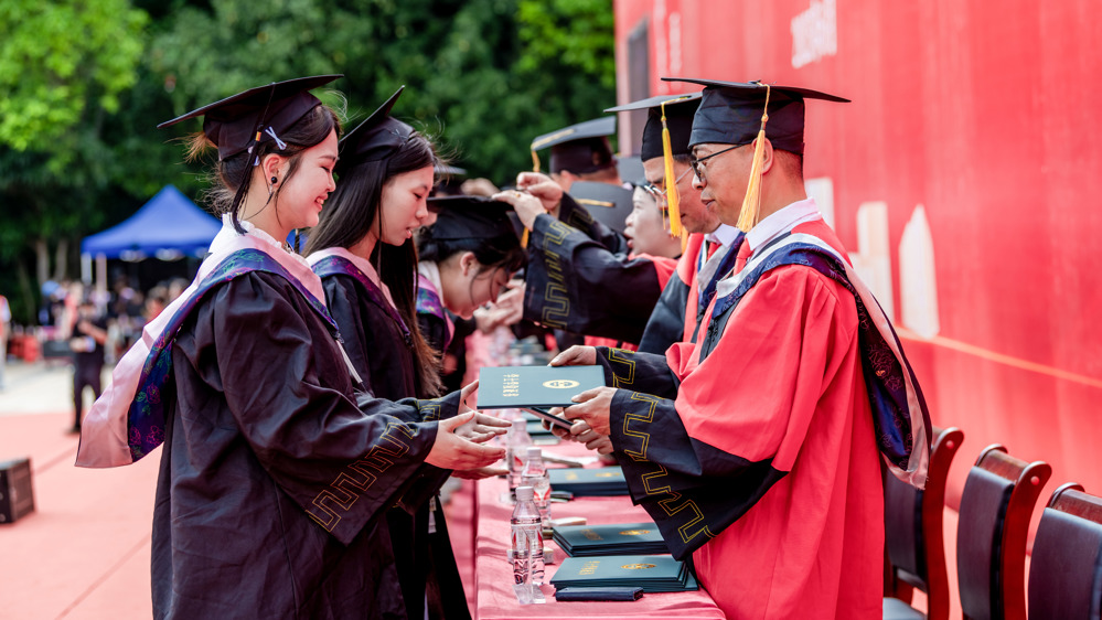 学校学位评定委员会成员及导师为毕业生们拨穗